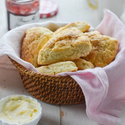 basket of scones with butter and jam.