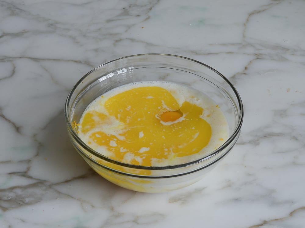 Egg in a bowl with wet ingredients.