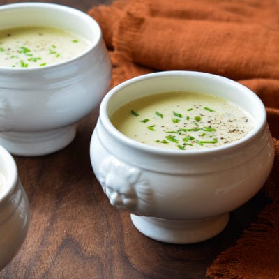 Two white crocks of potato leek soup.