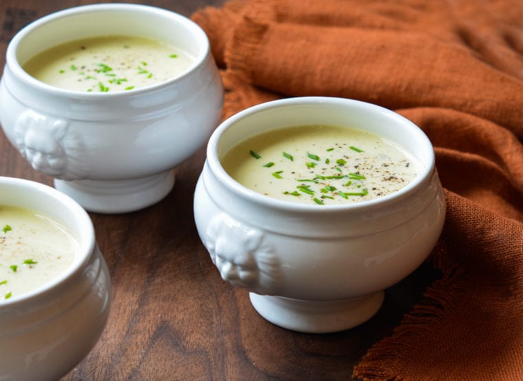 Two white crocks of potato leek soup.