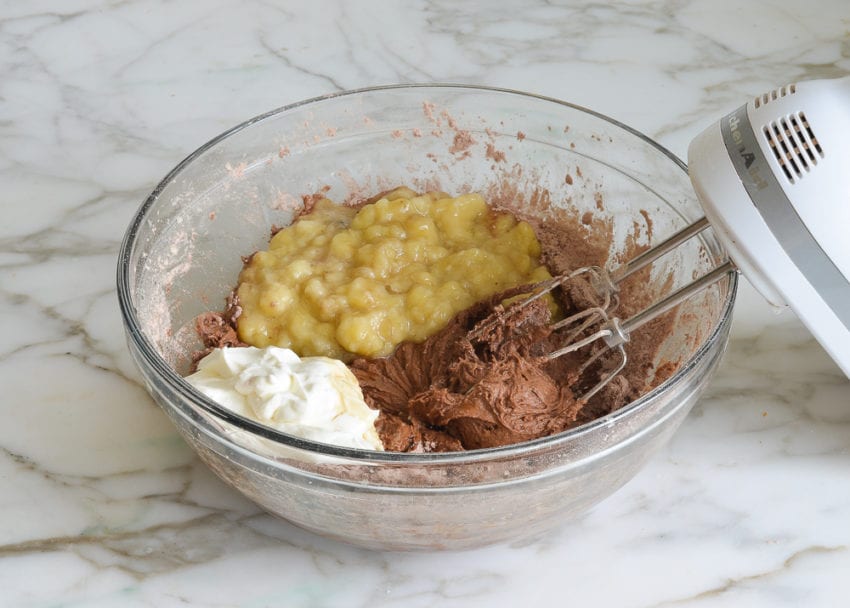 adding mashed bananas and sour cream to batter