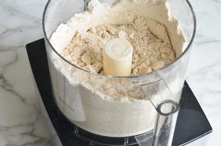 Food processor of finely ground nut mixture.