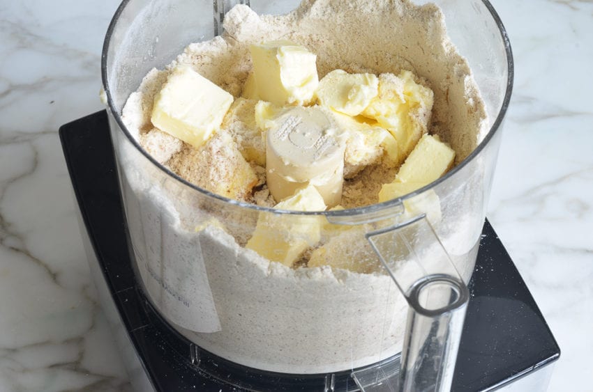 Butter in a food processor with a nut mixture.