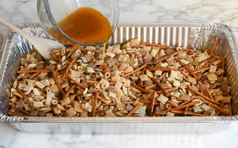 pouring the cereal over the chex mix