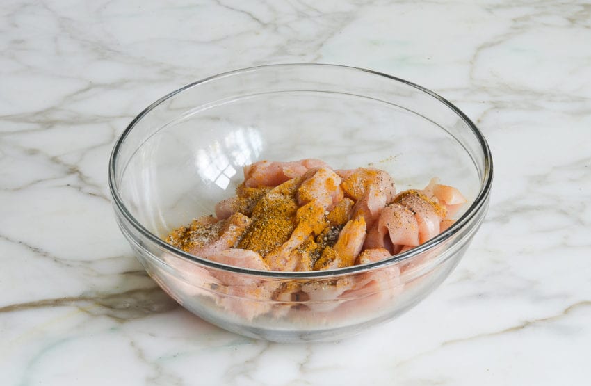 Seasoned chicken in a glass bowl.