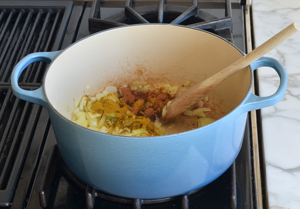 Spices in a Dutch oven with onions.