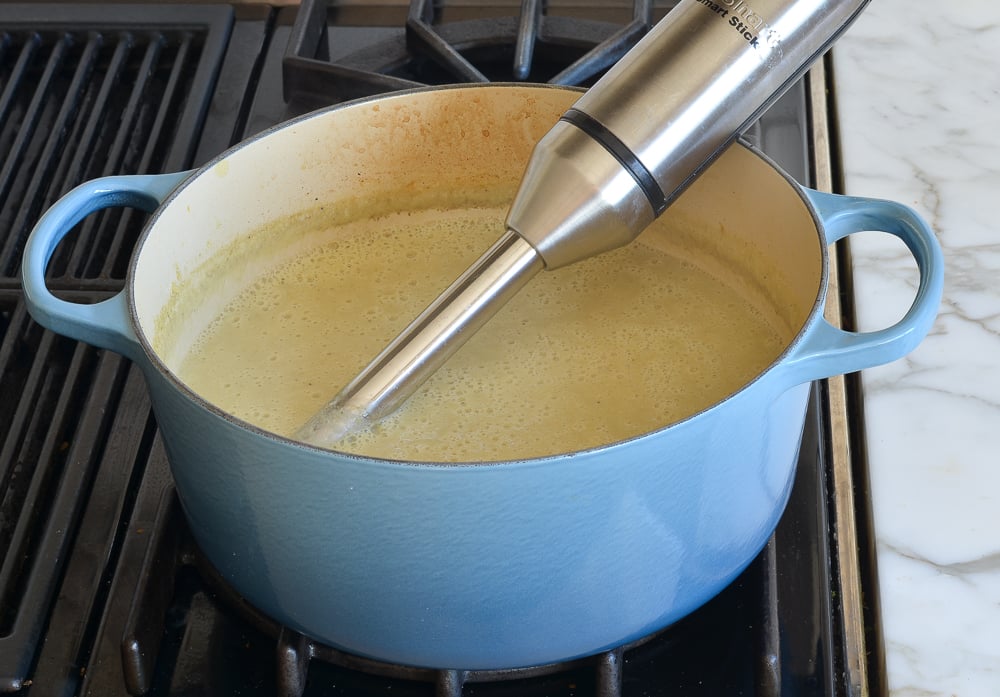 Immersion blender in a pot of soup.