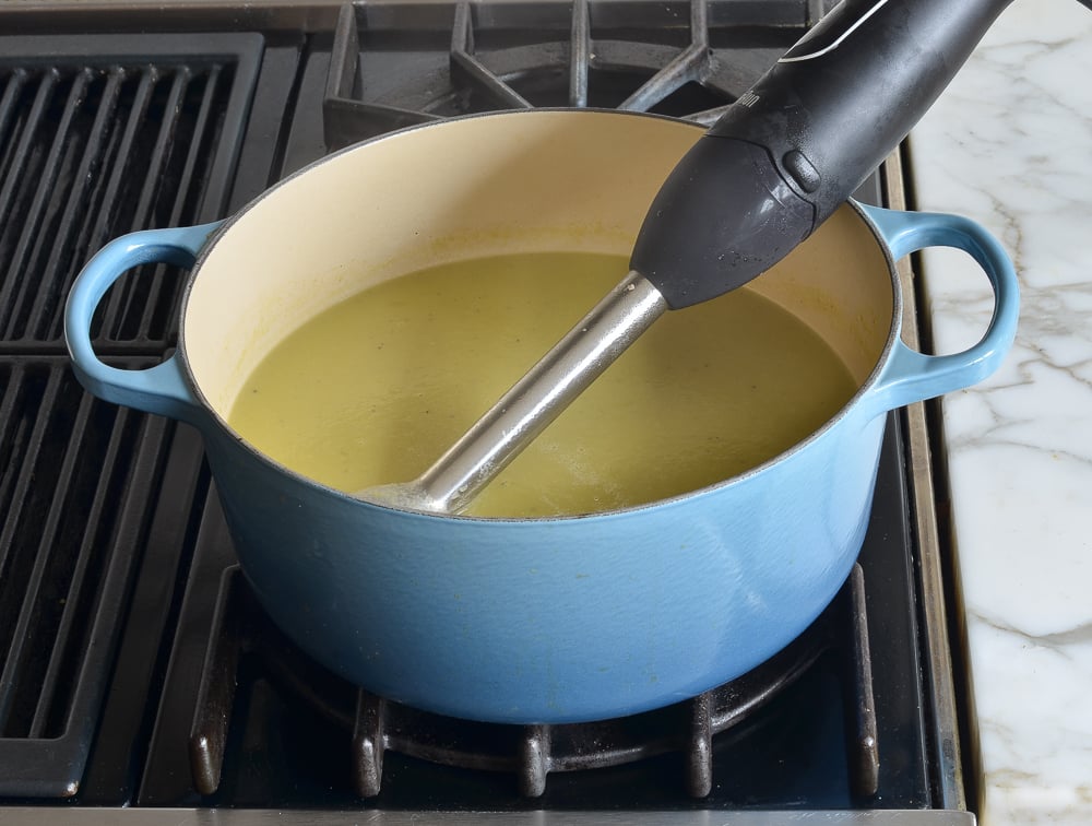 Immersion blender in a Dutch oven of soup.