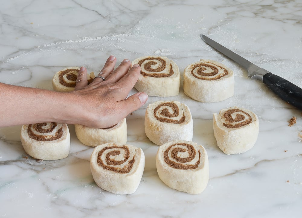 flattening the cinnamon rolls