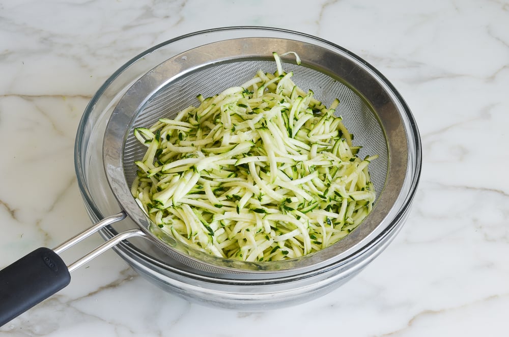 shredded zucchini in strainer