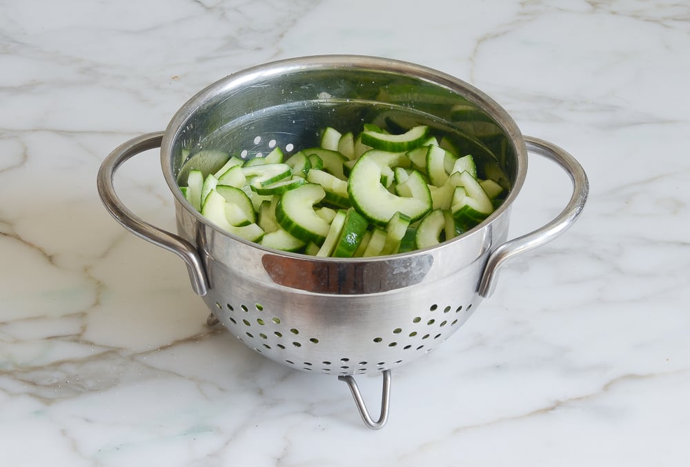 cucumbers and salt in a colander