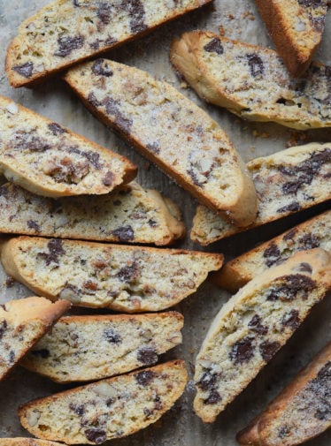 Slices of chocolate chip Mandel bread on parchment paper.