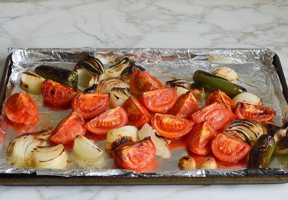 blistered and charred vegetables on baking sheet