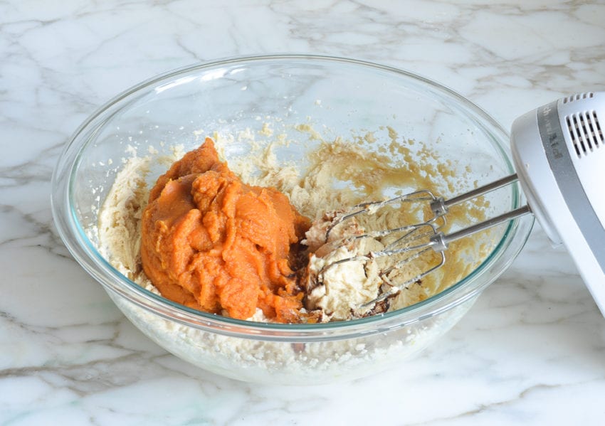 Pumpkin in a bowl with a butter mixture.