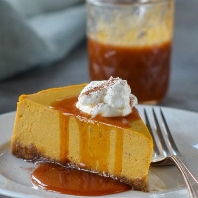 Slice of pumpkin cheesecake dripping with caramel sauce.