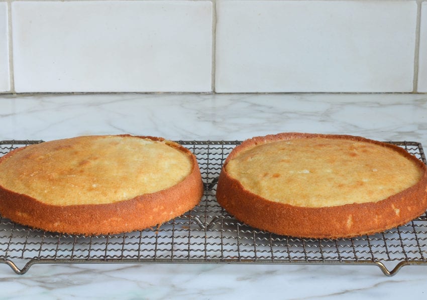 Two round cakes on a wire rack.