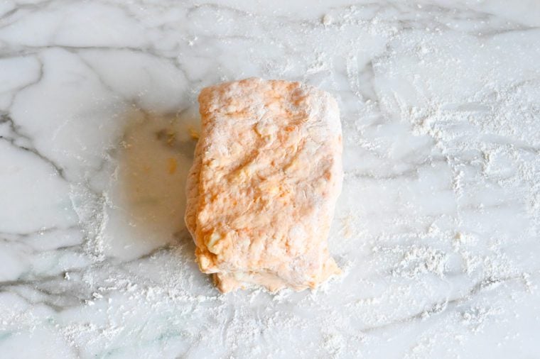 Stacked dough on a floured countertop.
