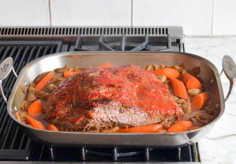 Pan with a partially cooked brisket.