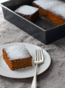 Slice of gingerbread on a plate with a fork.