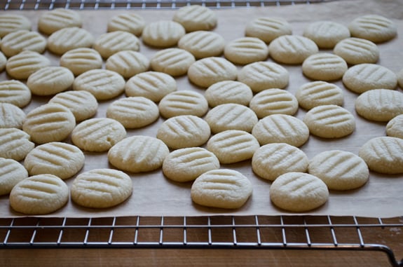 cooling-cookies Cookies on a wire rack with parchment paper.