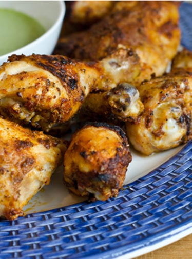 Plate of Peruvian-style roast chicken with green sauce.