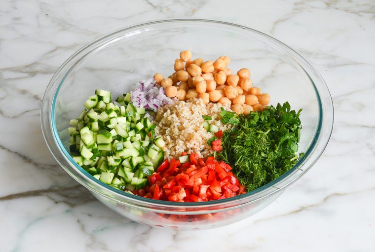 adding the bulgur and vegetables to the dressing