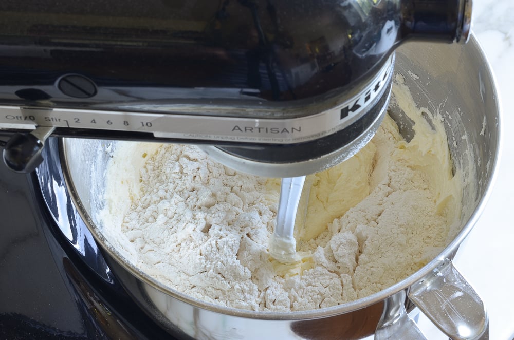 adding dry ingredients to sugar cookie batter