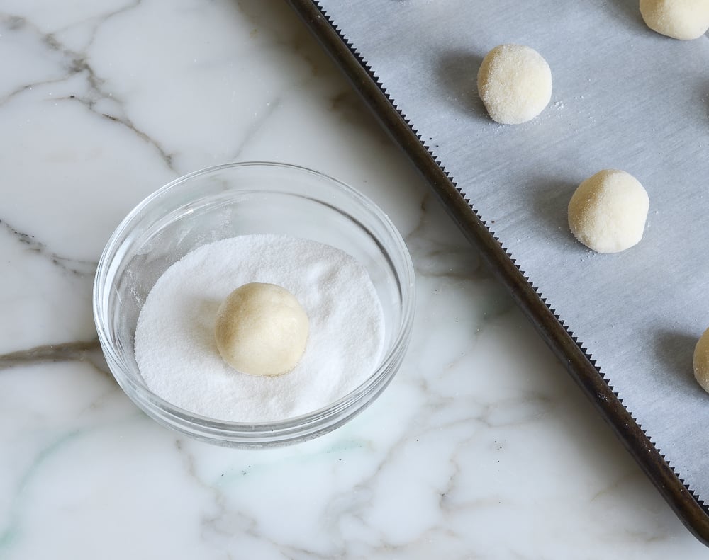rolling sugar cookie dough balls in sugar