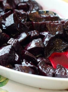 Spoon in a dish of roasted beets.