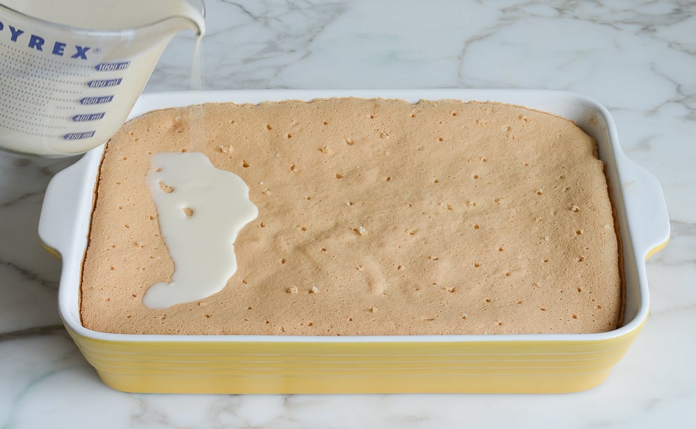 pouring soaking liquid on cake