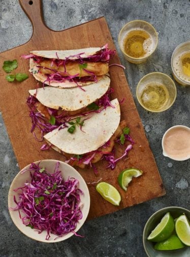 Baja fish tacos on a wooden cutting board.