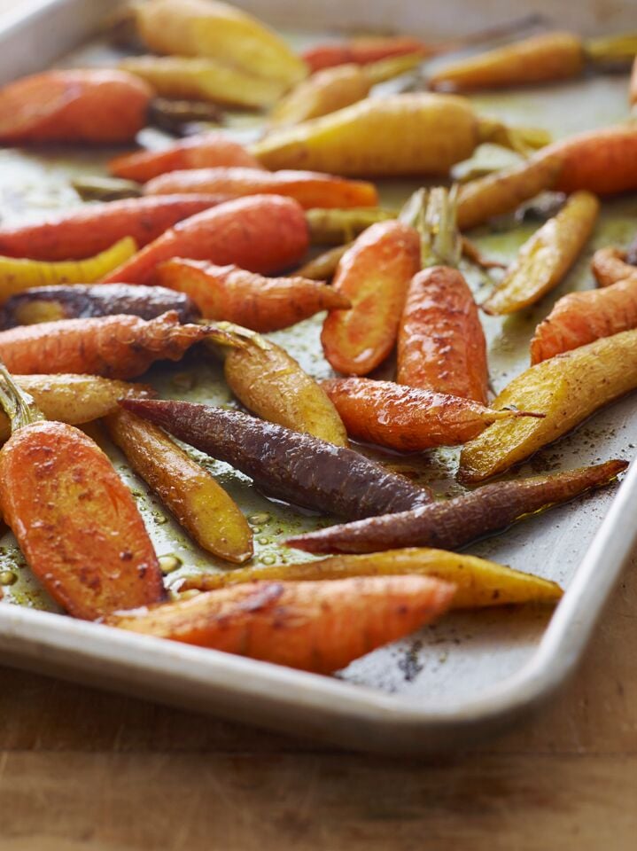 Curried roasted carrots on a baking tray.