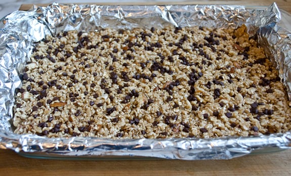adding-chocolate-chips Granola bar mixture topped with chocolate chips.