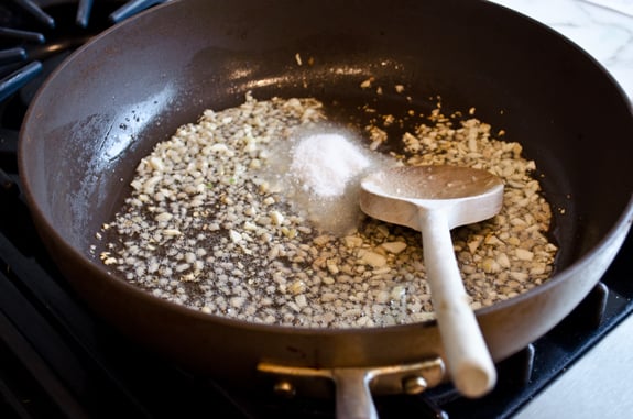 Sugar added to a skillet of ginger and garlic.