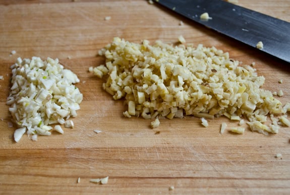 Minced garlic and ginger on a cutting board.