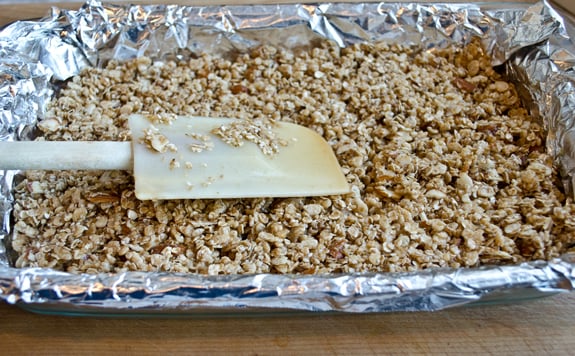 pressing-bar-mixture-into-pan Granola bar mixture in a lined baking pan.