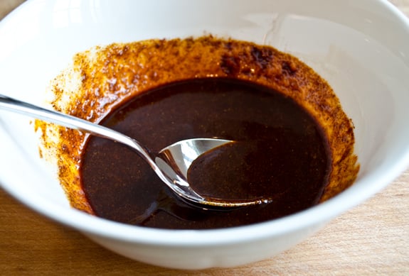Spoon in a bowl with a spice and butter mixture.