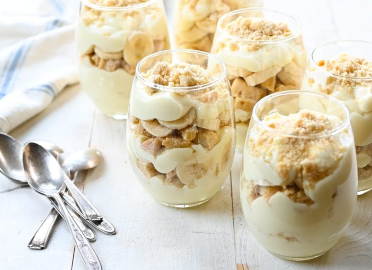 Multiple wine glasses of banana pudding parfaits.