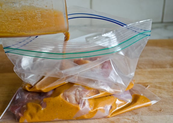 Marinade pouring into a bag with chicken.