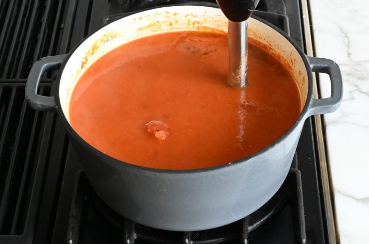 blending the soup with an immersion blender