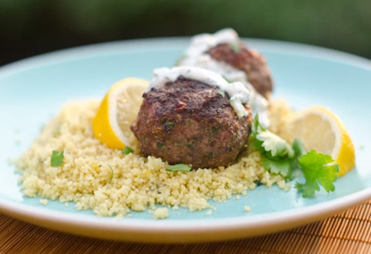 Grilled meatballs topped with cucumber yogurt dip.