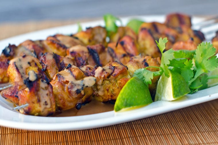 Grilled Thai curry chicken skewers on a plate.