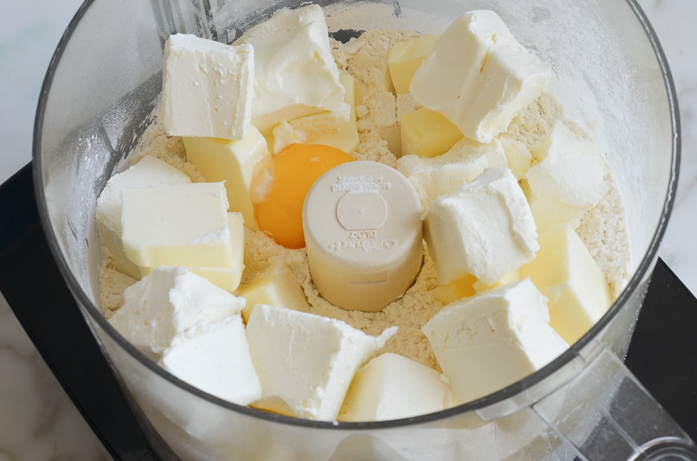 adding butter, cream cheese and egg yolk to the flour mixture