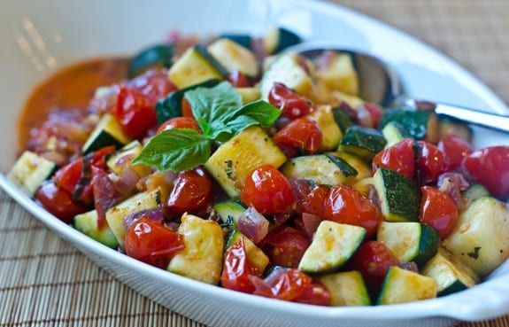Sauteed zucchini and tomatoes in a serving dish.
