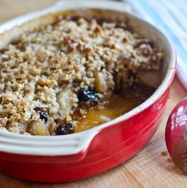 Baking dish of pear and dried cherry crisp with walnut streusel.
