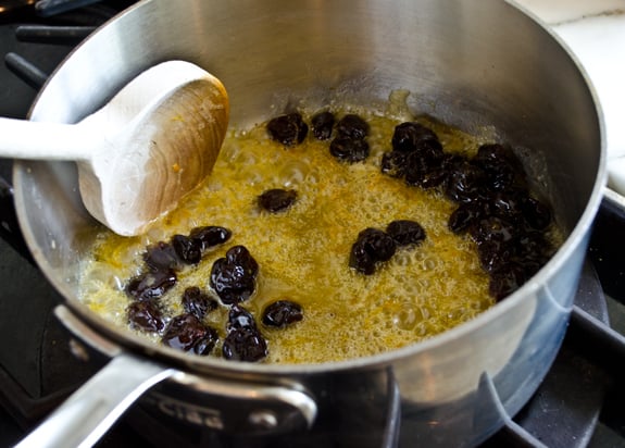 Dried cherries in a pan with a butter mixture.