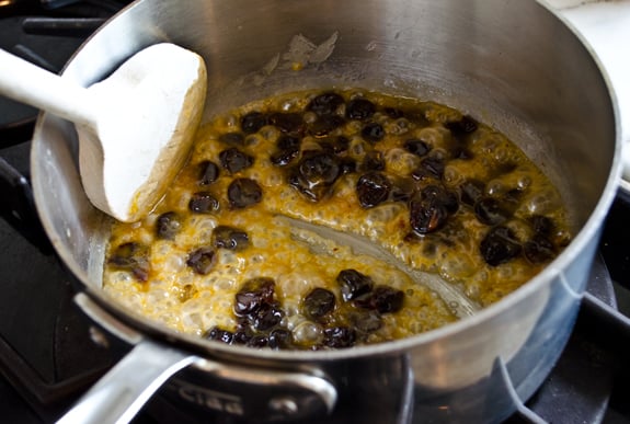 Dried cherries in a sauce pan with a butter mixture.