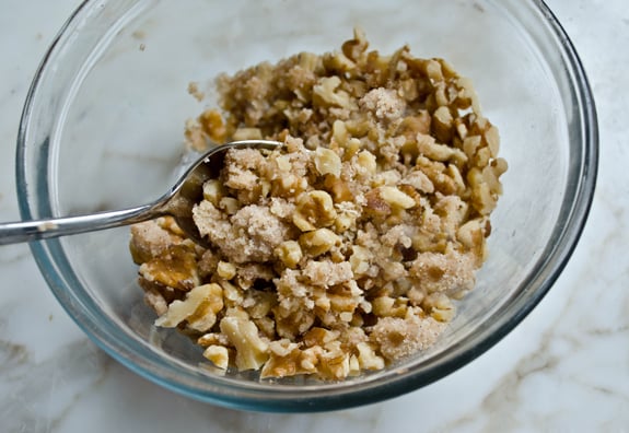 Walnuts in a bowl with a butter mixture.