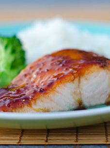 Seared salmon on a plate with broccoli and rice.