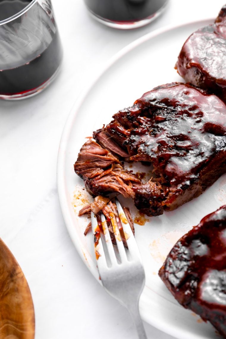 Fork on a plate with slow-baked barbeque short ribs.